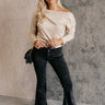 Full body front view of model wearing the Rooted Denim: Kamila Black Flare Jeans that have washed black denim fabric, a button-up fly, belt loops, two front pockets, two back pockets and flared legs.