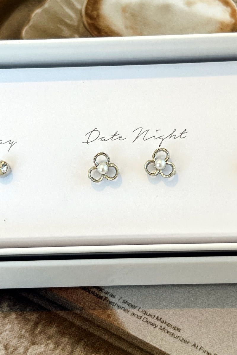 Close-up view of the 'date night' earrings with silver flowers and pearl centers.