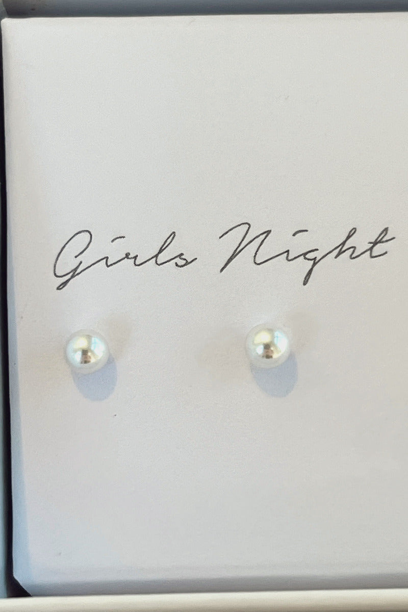Close-up view of the girls night pearl stud earrings.
