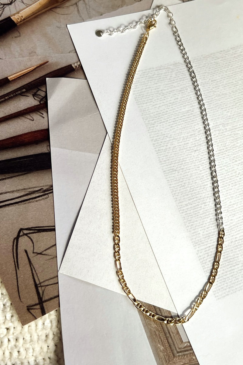 Flat lay of the Mixed Emotions Necklace which features mixed metal chain with gold and silver.