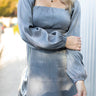Front view of model wearing the Star Light Dress features grey sheen fabric, a square neckline, smocked back detailing, and balloon long sleeves with elastic wrists.