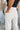 Close-up back view of model wearing the Isabella Corduroy Pants, that feature lightweight cream-colored corduroy, a button + zipper closure, front and back pockets, and wide legs