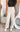 Front view of model wearing the Isabella Corduroy Pants, that feature lightweight cream-colored corduroy, a button + zipper closure, front and back pockets, and wide legs
