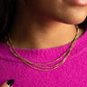 Close front view of model wearing the Valentina Gold Layered Necklace that has three gold layers with gold beads and gold bar design.