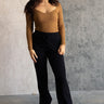 Full body view of model wearing the Aubrey Black Lounge Pants which features black cotton fabric, two front pockets, an elastic waistband with drawstring ties, and wide legs.