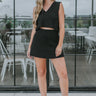 Full body front view of model wearing the Catalina Sweater Skirt in Black that has black knit fabric, mini length and an elastic waistband