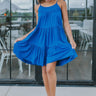 Full body front view of model wearing the Summer Shade Romper that has cobalt blue fabric, a two-tiered body, a scooped neckline, and tie straps.