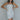 Front view of model wearing the Lost In A Dream Sequin Dress which features white square sequins, iridescent sequins, white lining, mini length, strapless and side zipper with hook closure.