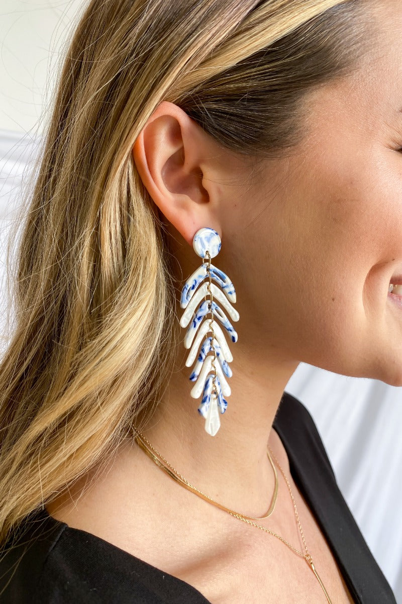 Side view of model wearing the Winter Dreams Earrings which features blue and white marble, leaf shaped dangles.