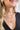 Close up view of model wearing the Follow Your Path Necklace which features gold triple layer necklace with a gold medallion.