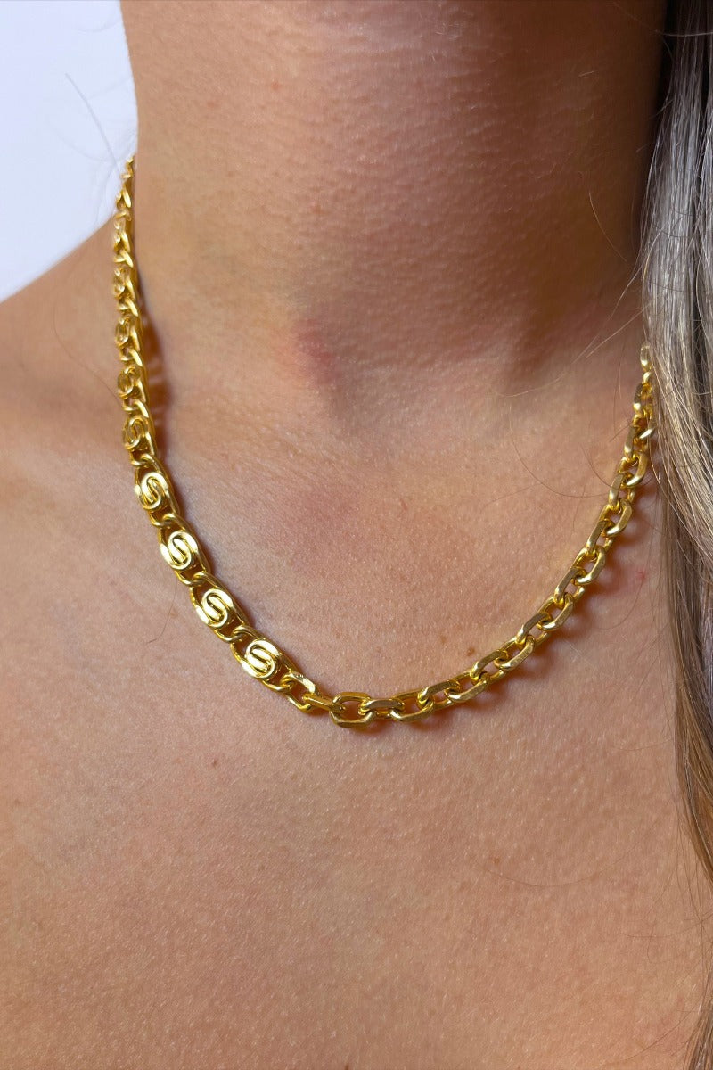 Front view of model wearing the Double Vision Necklace which features gold chain link with two different chain designs.