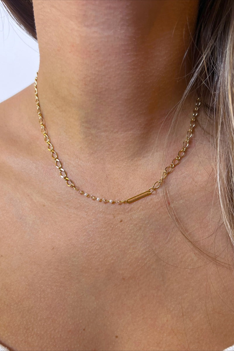 Front view of model wearing the Fairytale Ending Necklace which features single-layered gold chain link with clear beads.
