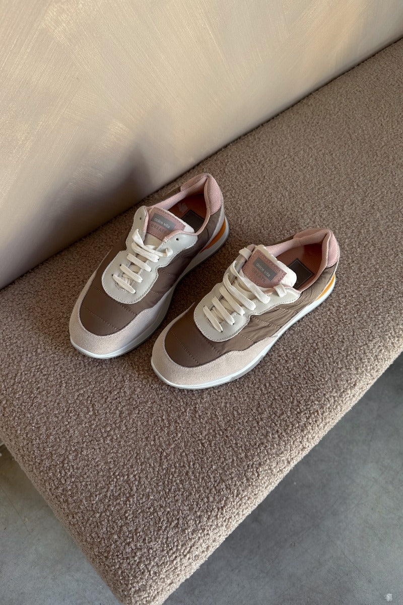 Ariel view of the Evana Sneaker which features a color-block design with taupe, cream, orange and light pink fabric, rubber outsole, lace-up tie design, mesh lining and 0.8" platform height.