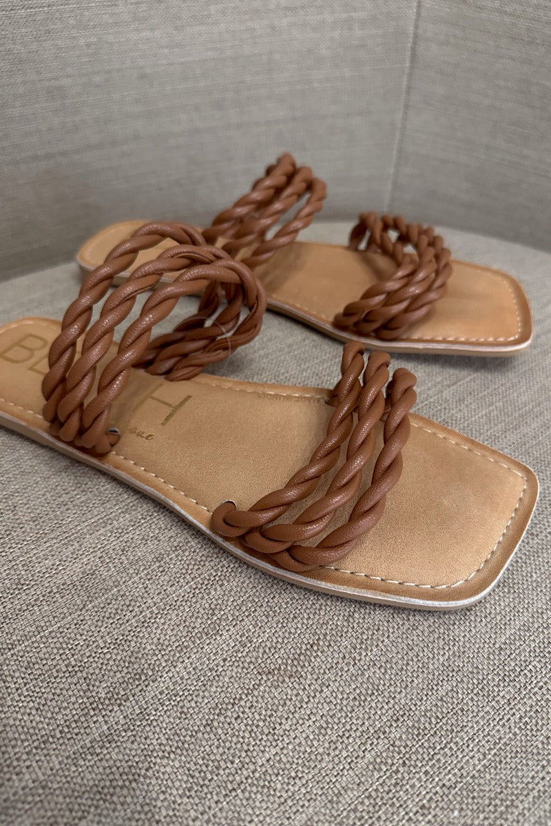 Close up view of the Amalia Flat Sandal in Tan which features light brown braided upper, two straps, slide-on style and flat sole. 