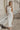 Image shows woman in a white maxi dress.