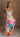 Blonde female model is wearing a pleated multi-color floral maxi dress
