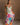 Blonde female model is wearing a pleated multi-color floral maxi dress