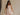 Image shows a brunette model. She is wearing a white, beige, and muted pink floral mini dress.