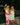 models standing arm in arm in green dresses