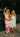 models standing arm in arm in green dresses