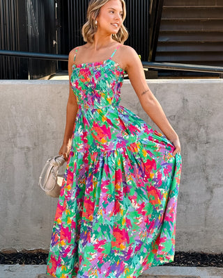 Full body front view of female model wearing a colorful printed maxi dress.