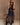 Model in t-shirt lace dress with black cowboy boots, a belt, and sunglasses