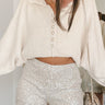 Close-up front view of model wearing the Afterglow Sequin Shorts, which feature a high-rise waist, a silver sequined material, an elastic waist band, and a flowy fit