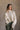 Front view of model wearing the Kaitlyn Beige Turtleneck Sweater that has beige knit fabric, ribbed hem, a ribbed turtleneck neckline, and long sleeves with ribbed cuffs.
