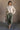 Full body front view of model wearing the Kaitlyn Beige Turtleneck Sweater that has beige knit fabric, ribbed hem, a ribbed turtleneck neckline, and long sleeves with ribbed cuffs.