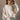 Front view of model wearing the Kaitlyn Beige Turtleneck Sweater that has beige knit fabric, ribbed hem, a ribbed turtleneck neckline, and long sleeves with ribbed cuffs.