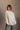 Front view of model wearing the Kaitlyn Beige Turtleneck Sweater that has beige knit fabric, ribbed hem, a ribbed turtleneck neckline, and long sleeves with ribbed cuffs.