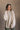 Front view of model wearing the Kaitlyn Beige Turtleneck Sweater that has beige knit fabric, ribbed hem, a ribbed turtleneck neckline, and long sleeves with ribbed cuffs.
