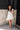 Full body view of model wearing the Elena Blue Multi Floral Mini Dress which features ivory white, light green and blue sheer fabric, floral print, ivory lining, mini length, plunge neckline, ruffle straps, sleeveless and open back with bow tie closure.