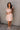 Full body front view of model wearing the Rory Blush Ruffle Sleeveless Mini Dress that has blush cotton fabric, mini length, square neckline, ruffle straps, sleeveless and smocked back.