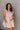 Front view of model wearing the Rory Blush Ruffle Sleeveless Mini Dress that has blush cotton fabric, mini length, square neckline, ruffle straps, sleeveless and smocked back.