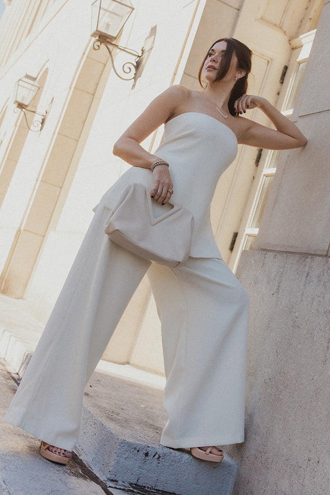 Full body view of model wearing the Grace Ivory Wide Leg Pants which features ivory textured fabric, two side slit pockets, monochrome side pockets, and wide pant legs.