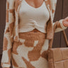 Close-up front view of model wearing the In Your Dreams Skirt, that has an ivory stretchy knit material, a mocha colored geometric print, a high-rise fit, a thick waist band, and a mini length. Worn with white tank and matching top.