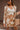 Front view of model wearing the In Your Dreams Top, that has an ivory knit material, a mocha geometric print, a collar neck, a long sleeve, and a button-up front. Worn over whit tank with with matching skirt.