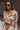 Front view of model wearing the In Your Dreams Top, that has an ivory knit material, a mocha geometric print, a collar neck, a long sleeve, and a button-up front. Worn over whit tank with with matching skirt.