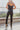 Back view of the Next Level Straight Leg Pants that features a black faux-leather material, a high-rise fit, a clasp and zipper front closure, belt loops, two front pockets, a middle seam down the legs, and a straight leg fit.