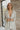 Front view of the Glitz and Glam Blazer features champagne glitter fabric, champagne button closures, low collared neckline, has a lining, left chest pocket and long sleeves.