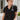 Frontal view of the Irreplaceable Top that features a black colored material, a round neckline with a ruffle detail, a tie detail with a cut-out at the chest, a short sleeve, and a fowy fit