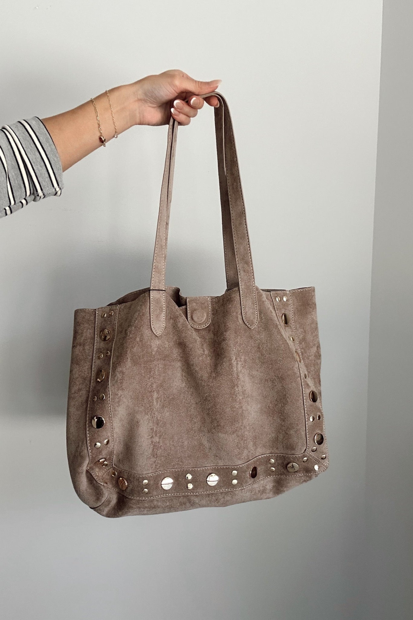 Angela Taupe Suede & Studs Tote - model shown holding tote