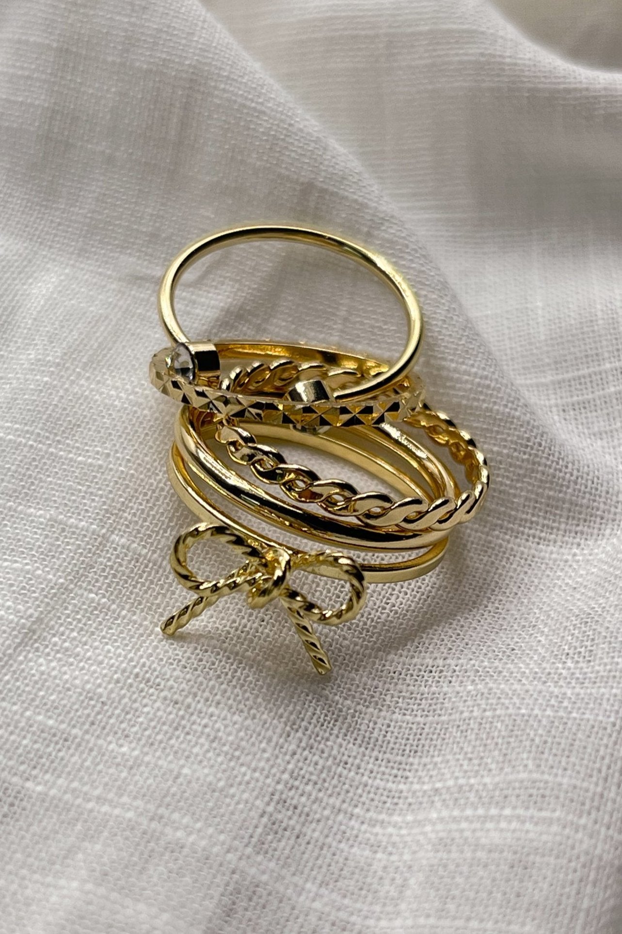 Image shows the Heather Gold Bow Ring Set stacked against a beige background.