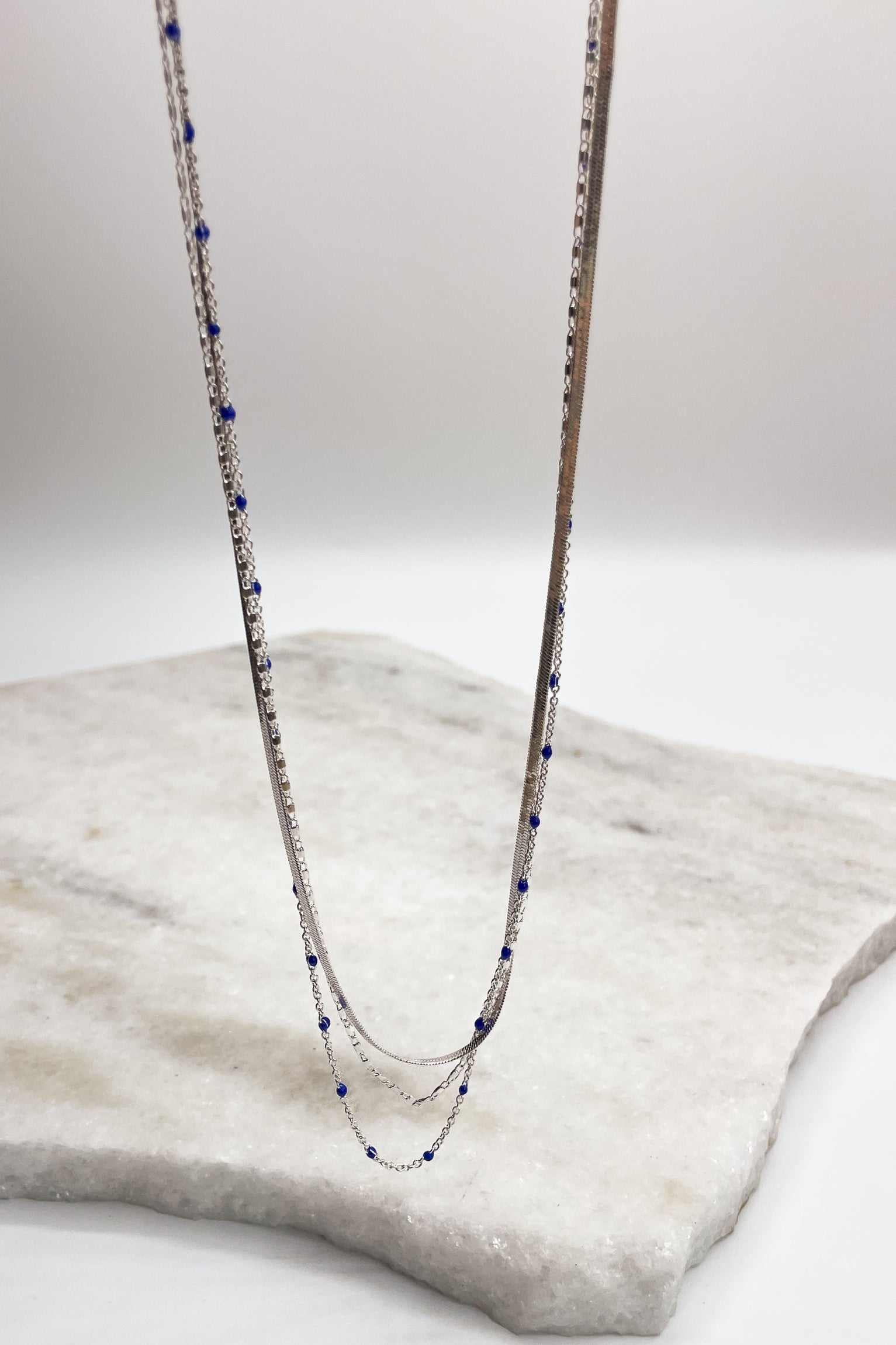 Close up of Kenzie Silver Layered Necklace, silver chain link layer with blue beads.