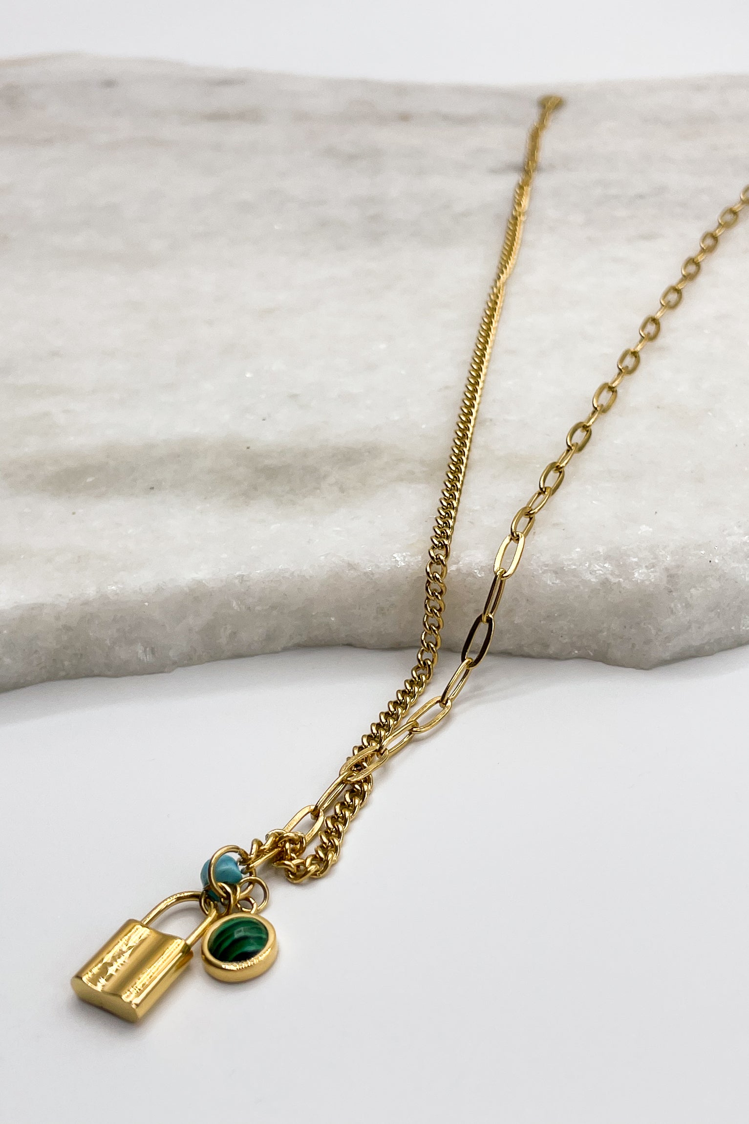 Close up of Meredith Gold Lock and Bead Necklace, adjustable gold chain link with a gold lock medallion and turquoise beads.