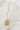 flat lay view of the Orion Sun Gold Necklace which features adjustable gold chain link with rectangle medallion. the medallion says "the sun" with a sun detail