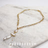 Close up of the Amara Gold Pearl Necklace. This is a hammered gold chain necklace with 3 rectangular pearl pendants.