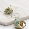 Close up of Diana Green Shell Earrings. These are green seashell earrings with gold accents.