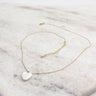 Close up of Skylar Gold Heart Necklace. This is a gold necklace with a white heart.